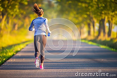 Runner woman in autumn park tree alley training in sports thermal underwear Stock Photo