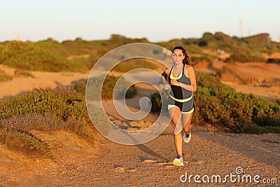 Runner woman running in the mountain towards camera Stock Photo