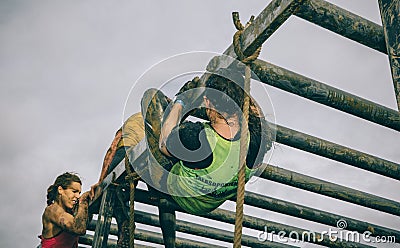 Runners climbing structure in a test of extreme obstacle race Editorial Stock Photo
