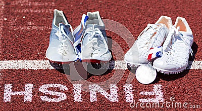 Runniners racing spikes at finish line with gold and siver medals Stock Photo