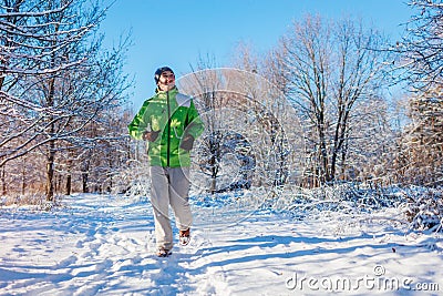 Running athlete man sprinting in winter forest. Training outside in cold snowy weather. Active healthy way of life Stock Photo