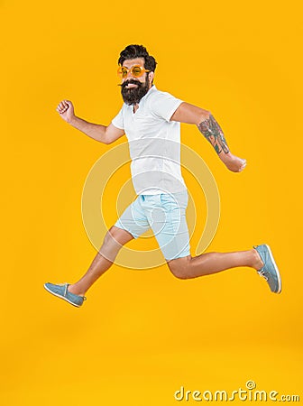 running caucasian stylish guy in studio isolated on yellow background Stock Photo