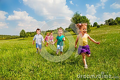 Running children in green field during summer Stock Photo