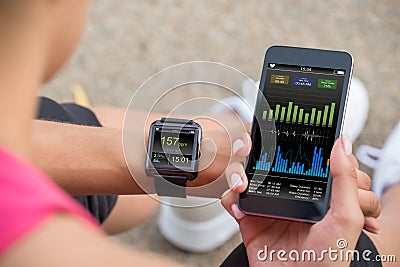 Running Female With Mobile Phone Connected To A Smart Watch Stock Photo