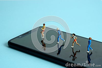 Running and jogging tracking app concept. A family running above smartphone. Miniature people figure photography Stock Photo