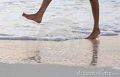 Running kids legs in shallow sea water Stock Photo