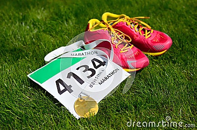 Running shoes, marathon race bib (number) and finisher medal on grass background, Stock Photo