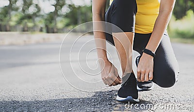 Running shoes runner woman tying laces for autumn run in forest park. Runner trying running shoes getting ready for run. Jogging g Stock Photo