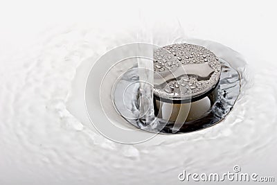 Running tap water in a sink down the drain Stock Photo