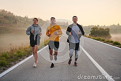 Running towards a common goal, a group of colleagues braves the misty morning air, their determination evident in every Stock Photo