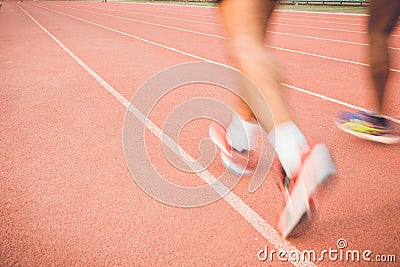 Running track with blur of runner feet in stadium Stock Photo