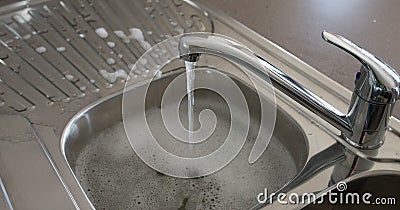 Running Water Over Kitchen Sink. Stock Photo