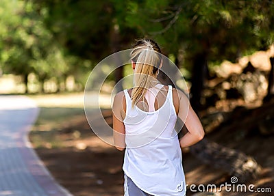 Running woman in park in summer training. Pretty sport fitness model in sporty running clothes Stock Photo