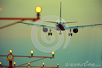 Silhouette of plane landing, runway lights, orange effect Stock Photo