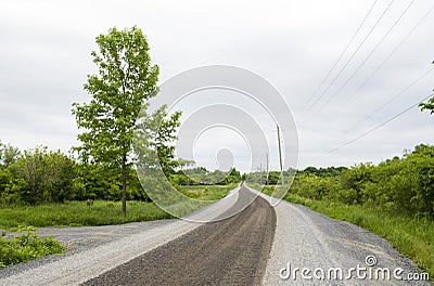 Rural gravel country road on a cloudy day landscape Stock Photo