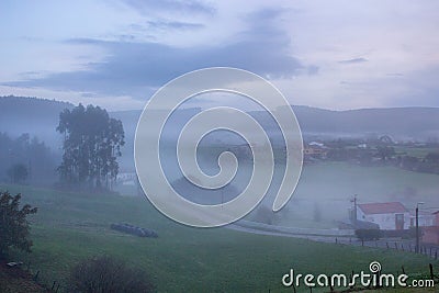 Rural landscape in the morning fog. Misty village in the morning. Autumn at countryside. Fall in the valley. Stock Photo