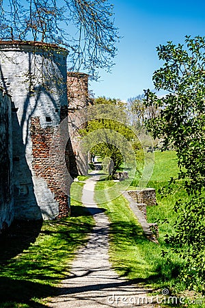 Rural path leading past two circular brick towers Stock Photo