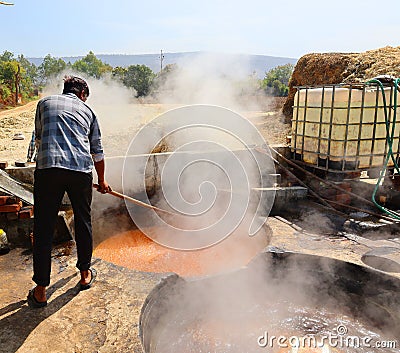 Man working in a factory boiling sugar cane. Editorial Stock Photo