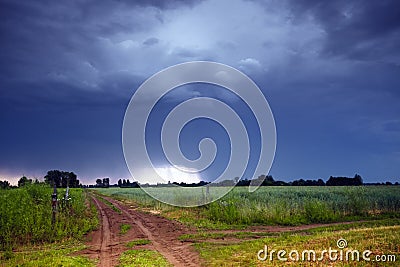 Rural road and dark storm clouds Stock Photo