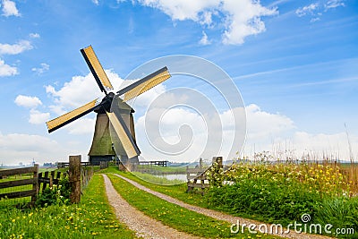 Rural road and windmill in Netherlands Stock Photo