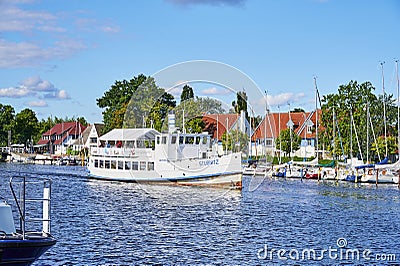 Rural scene on the banks of the river Ryck in Northern Germany with sailing boats and a historic steamer Editorial Stock Photo