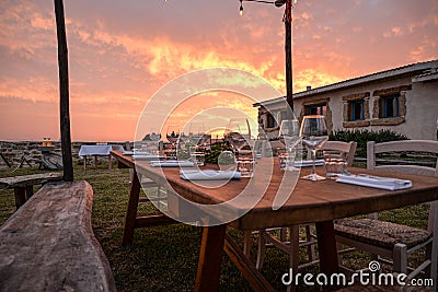 Dining outdoor in Italy. Decked table al fresco by sunset Stock Photo