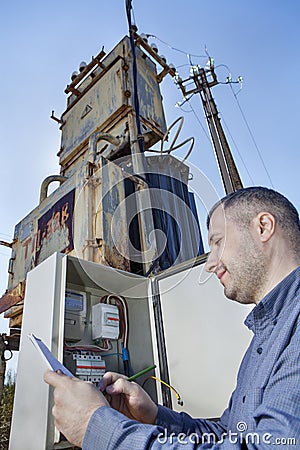 Rural Technician reading the electricity meter to check consumption. Stock Photo