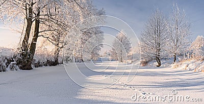 Rural Winter Landscape In Pastel Colors With Frozen River,Surrounded By Snowy Trees And Small Wood House On The River Bank. Belaru Stock Photo