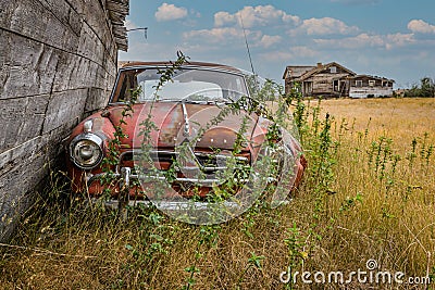 Rush Lake, SK- August 19, 2021: An abandoned Borgward Isabella TS and abandoned farmhouse on the Saskatchewan prairi Editorial Stock Photo