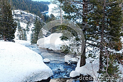 A rushing stream flows through a winter landscape Stock Photo