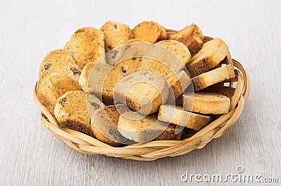 Rusks with raisin in wicker basket on table Stock Photo
