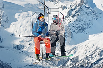 Russia, Dombai-February 7, 2017: Two skiers lift to the Ski Resort high in the winter snow mountains at chair cable car Editorial Stock Photo