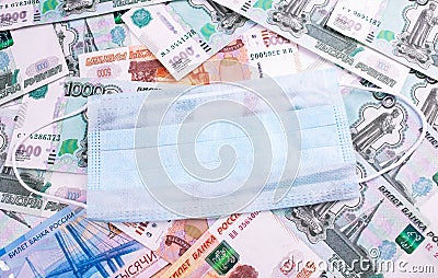 Russia embraces quarantine. Russian money rubles with face mask. Stock Photo