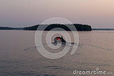 Russia, Karelia. White nights. Lake Muezero. Man on an inflatable boat floating on the lake Editorial Stock Photo