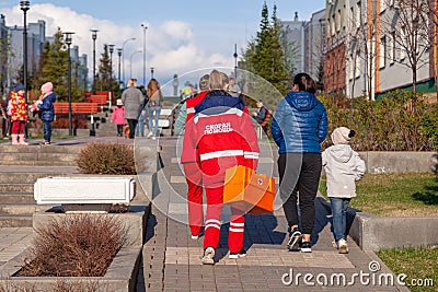 Russia Kemerovo 2019-05-21 Ambulance team of a woman in a red uniform with an orange medicine case is walking down the Editorial Stock Photo