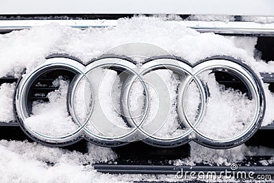 Russia Kemerovo 2018-12-23 closeup metal emblem brand icon Audi A6 with four rings, covered with fluffy snow. Concept German Editorial Stock Photo