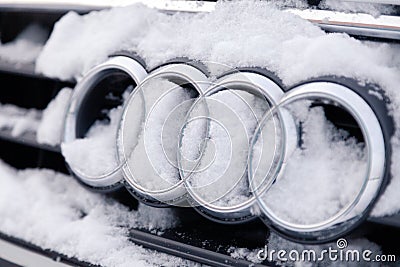 Russia Kemerovo 2018-12-23 closeup metal emblem brand icon Audi A6 with four rings, covered with fluffy snow. Concept German Editorial Stock Photo