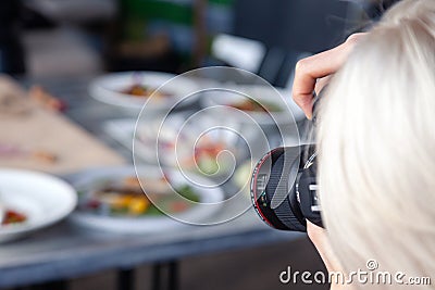 Russia Kemerovo 2019-03-10 girl photographer taking pictures on professional camera Canon 5D Mark IV and various dishes, salads on Editorial Stock Photo