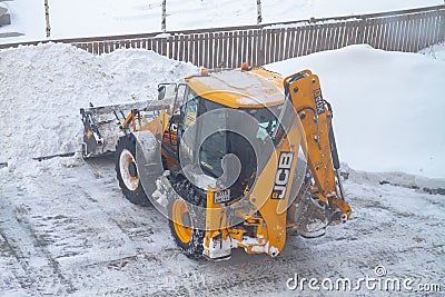 02 06 2022 Russia Kostroma Orange Bulldozer for clearing snow cleans snow on the road in winter Editorial Stock Photo