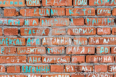 Russia, Leningrad region, November 2020. A fragment of the brick wall of the restored temple with the names of people. Editorial Stock Photo