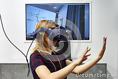 RUSSIA, MOSCOW - APRIL, 04, 2019 Young blonde girl in augmented reality headset. Editorial Stock Photo