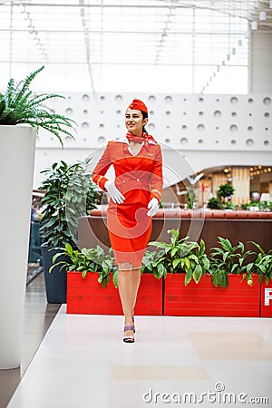 RUSSIA, MOSCOW: 01 AUGUST 2019. Beautiful stewardess dressed in official red uniform Aeroflot Airlines Editorial Stock Photo