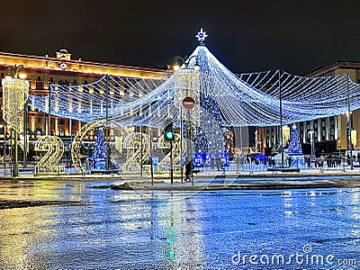 A tall Christmas tree with beautiful decorations and a large bright garland in Moscow Editorial Stock Photo