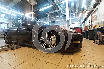 Russia, Moscow - May 04, 2019: Brown Porsche Panamera in the service center Repairing of pneumatic suspension. Diagnostics of a Editorial Stock Photo