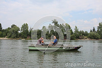 Russia, male fishermen sail in a motor boat on the river in summer for tourism and recreation Editorial Stock Photo