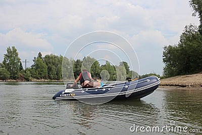 Russia, male fishermen sail in a motor boat on the river in summer for tourism and recreation Editorial Stock Photo