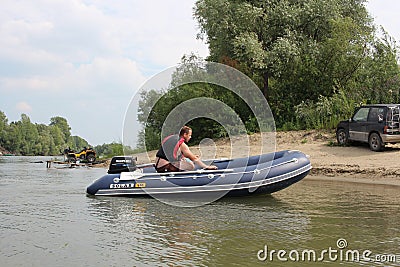 Russia, male fishermen sail in a motor boat on the river in summer for tourism and recreation Editorial Stock Photo