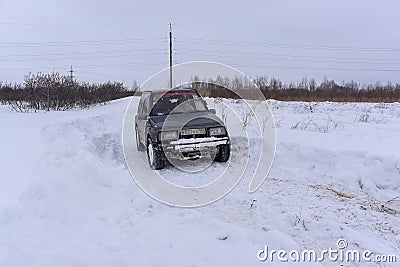 Offroad SUV `Suzuki Escudo` 4x4 goes fast on a snowy road in winter Editorial Stock Photo