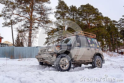 Offroad SUV `Suzuki Escudo` 4x4 with off-road training stands on a snowy road in the forest Editorial Stock Photo