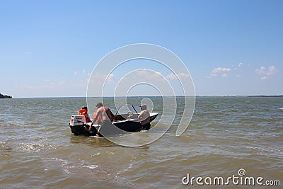 men swim in a motor boat in life jackets on a boat in the summer in the river Editorial Stock Photo